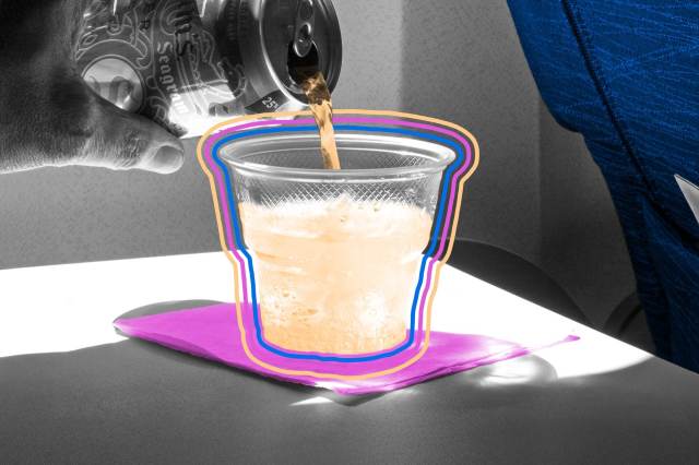 Passenger pouring ginger ale in plastic cup aboard airplane