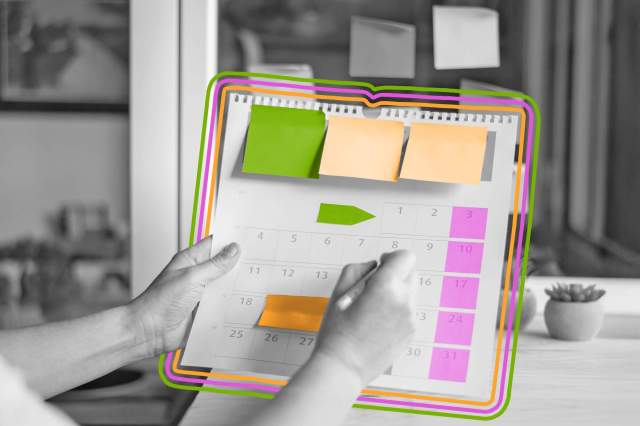 Physical calendar covered in sticky notes