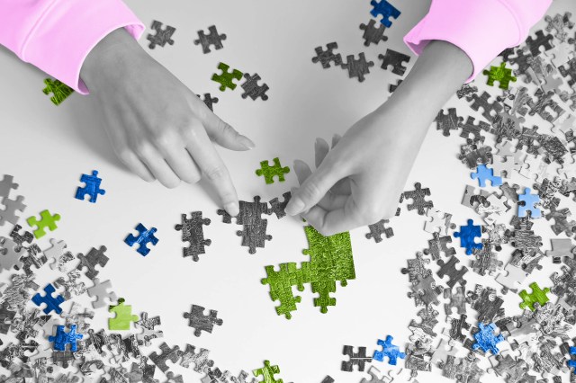 Hands putting together a jigsaw puzzle
