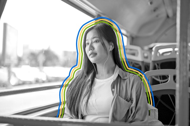 Woman riding public transit wearing earbud headphones