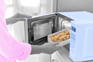 Woman putting dish of rice in microwave
